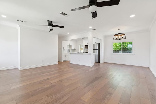 unfurnished living room featuring visible vents, ceiling fan with notable chandelier, ornamental molding, and light wood-style flooring