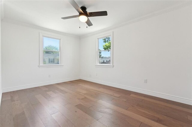 spare room with crown molding, wood-type flooring, and a healthy amount of sunlight