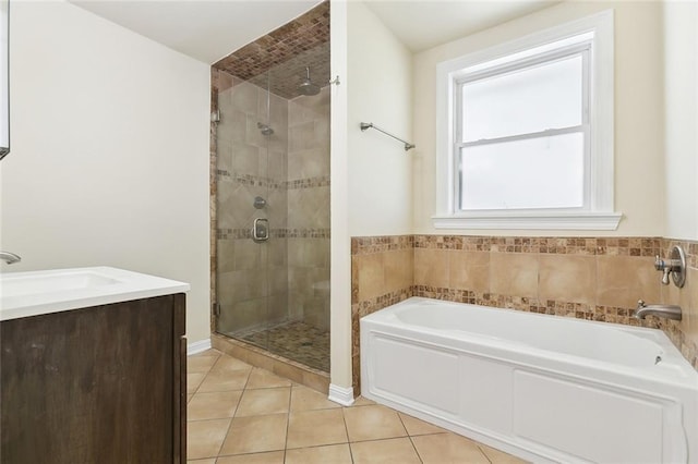 bathroom with a shower stall, tile patterned flooring, vanity, and a bath