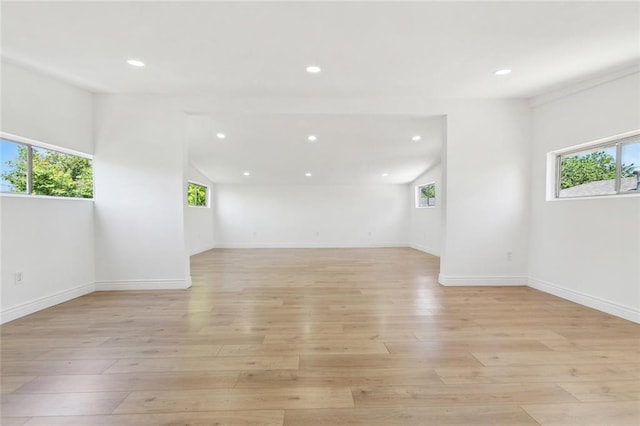 empty room with light wood finished floors, baseboards, recessed lighting, and a wealth of natural light