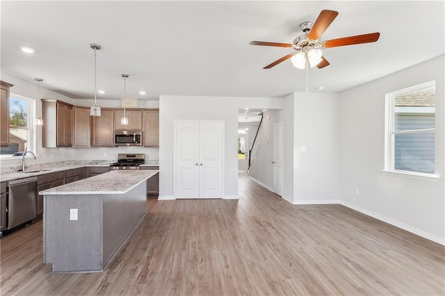 kitchen with appliances with stainless steel finishes, ceiling fan, a sink, and a wealth of natural light