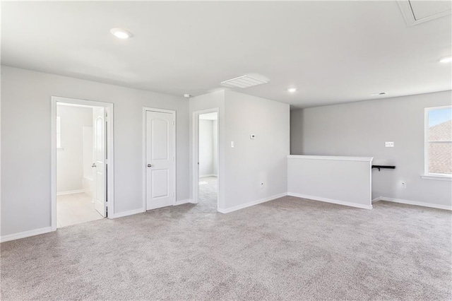 spare room with light carpet, baseboards, visible vents, and recessed lighting