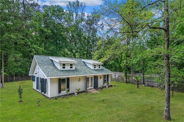 back of property featuring a lawn, french doors, a fenced backyard, and roof with shingles