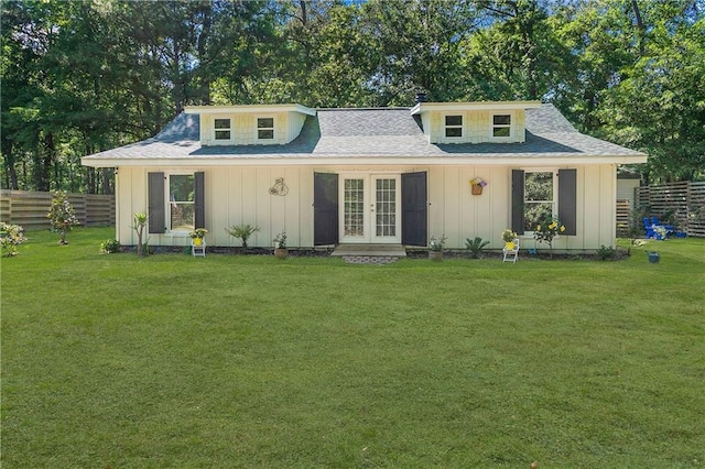 view of front of property featuring a front lawn, board and batten siding, fence, and french doors