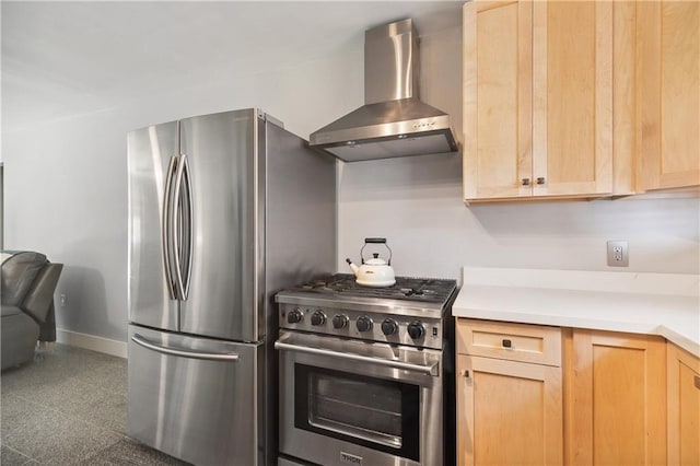 kitchen with light brown cabinets, baseboards, light countertops, wall chimney exhaust hood, and stainless steel appliances