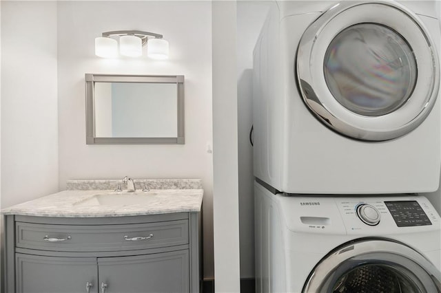clothes washing area featuring a sink, cabinet space, and stacked washer / drying machine
