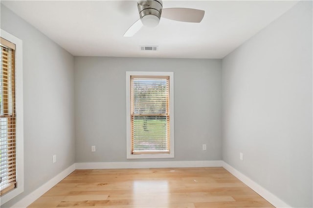empty room featuring visible vents, baseboards, and wood finished floors