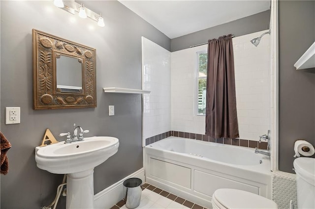 bathroom featuring toilet, baseboards, shower / washtub combination, and tile patterned floors