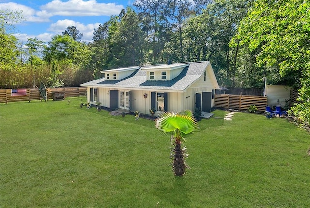 back of property featuring a lawn, fence, and french doors