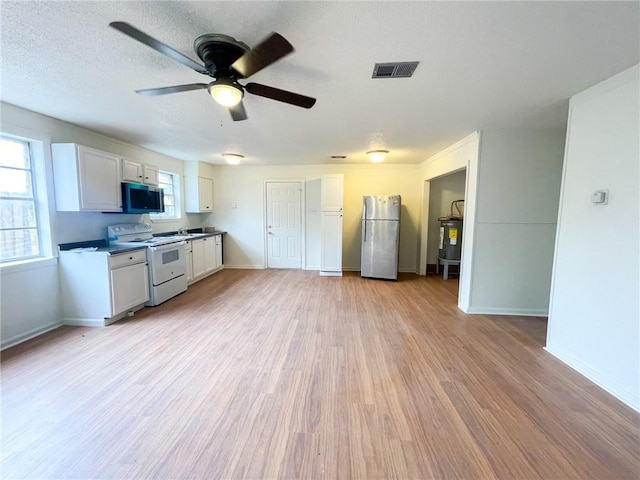 kitchen featuring visible vents, baseboards, ceiling fan, appliances with stainless steel finishes, and light wood-style flooring