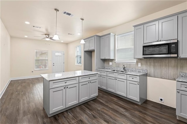 391214 Thalia St, New Orleans, LA 70125 - kitchen featuring a sink, stainless steel microwave, gray cabinetry, and visible vents