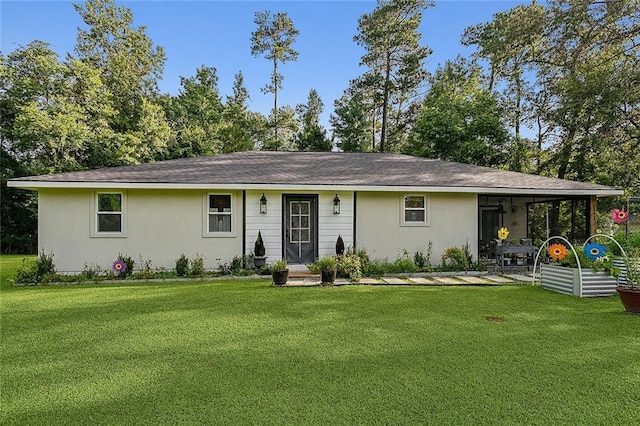 ranch-style house with roof with shingles, a front lawn, and stucco siding