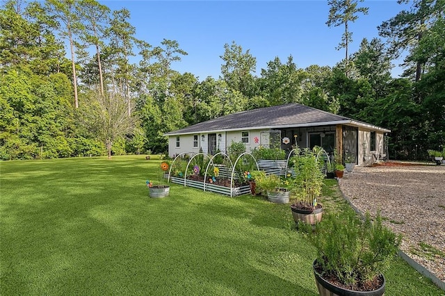 view of front of home with a front yard and a garden