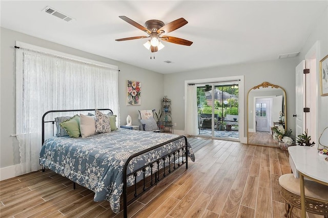 bedroom featuring visible vents, access to exterior, and wood finished floors