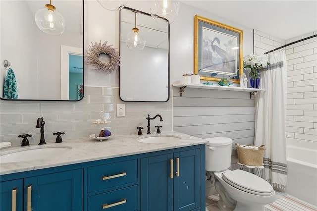 bathroom featuring toilet, decorative backsplash, double vanity, and a sink