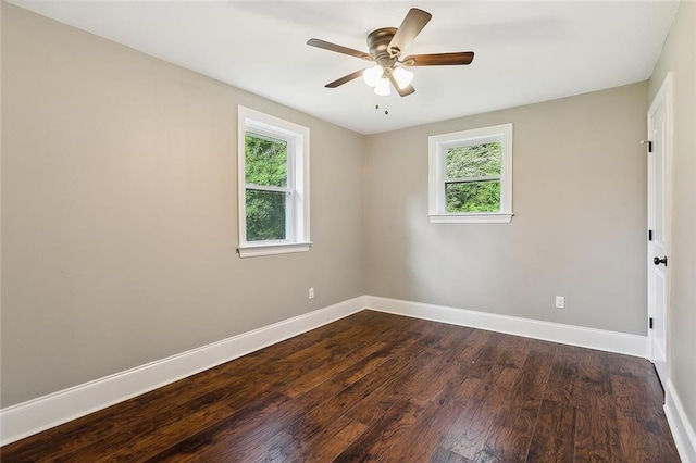 unfurnished room featuring dark wood-type flooring, ceiling fan, baseboards, and plenty of natural light