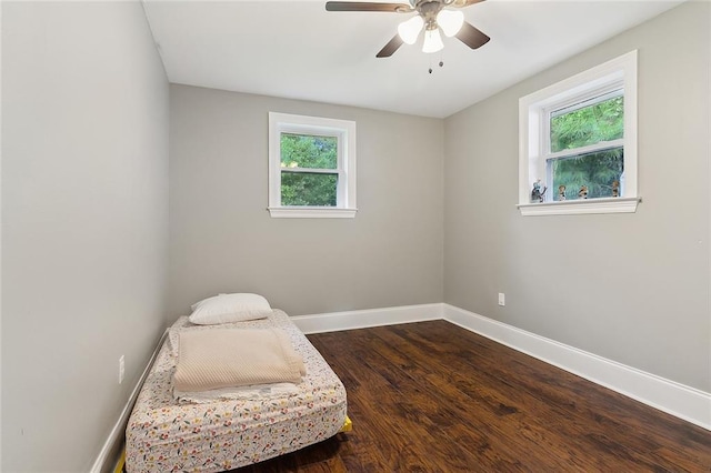 sitting room featuring dark wood-style floors, a ceiling fan, and baseboards