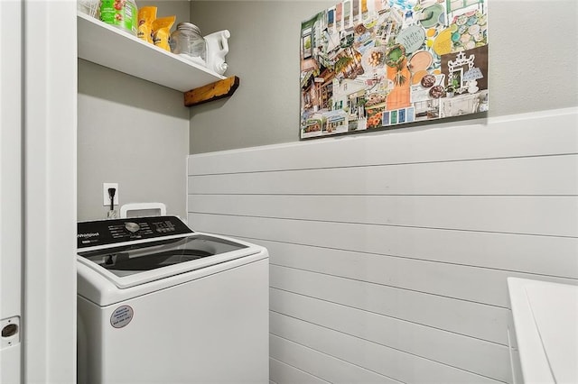 laundry room featuring washer / clothes dryer, a wainscoted wall, and wooden walls