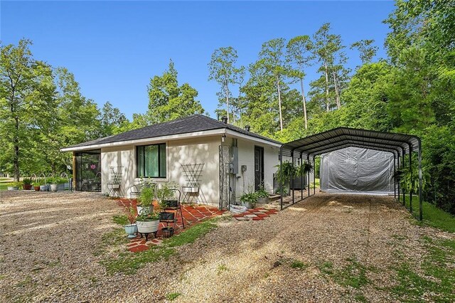 view of front facade featuring dirt driveway and a carport