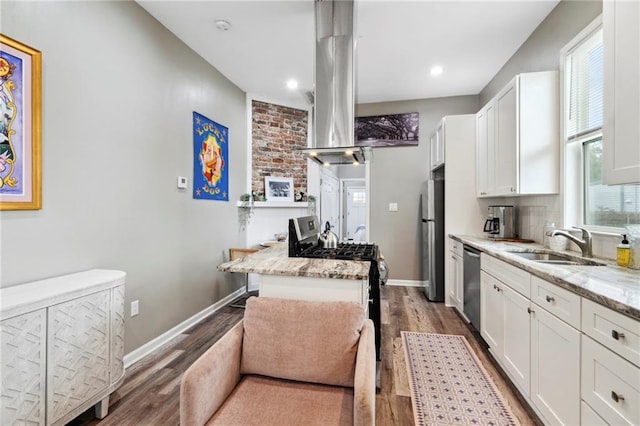 202729 Cambronne St, New Orleans, LA 70118 - kitchen featuring white cabinets, a sink, appliances with stainless steel finishes, wood finished floors, and island exhaust hood