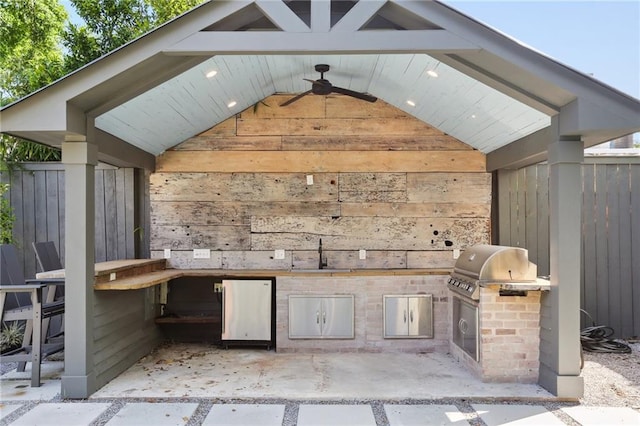 view of patio featuring exterior kitchen, a grill, a sink, and fence