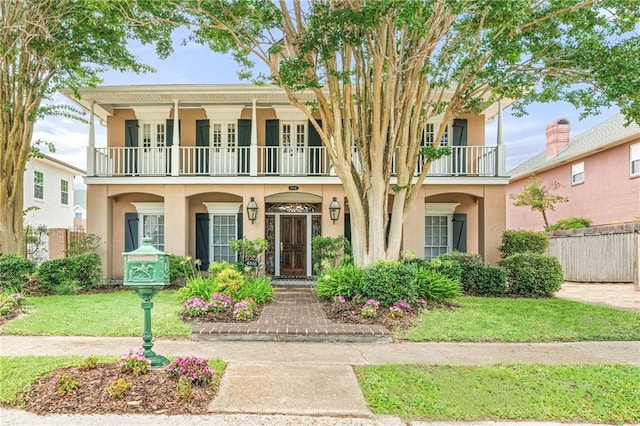 4516 Beau Lac Ln, Metairie, LA 70002 - view of front of house featuring a balcony, stucco siding, french doors, and a porch