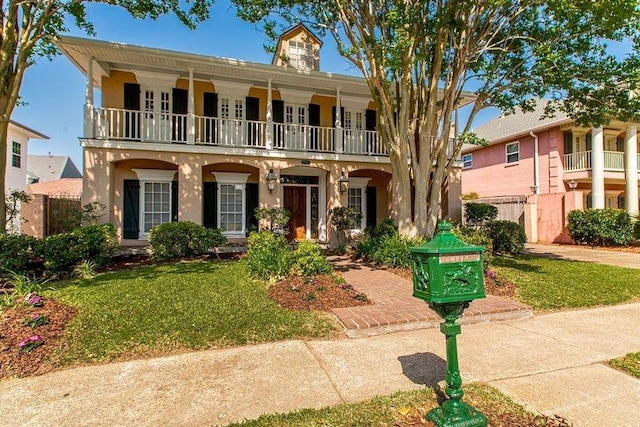 4516 Beau Lac Ln, Metairie, LA 70002 - view of front facade with a front yard, stucco siding, and a balcony