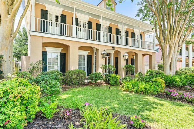 4516 Beau Lac Ln, Metairie, LA 70002 - view of front facade featuring a balcony, stucco siding, and a front lawn