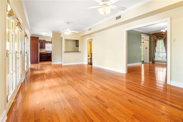4516 Beau Lac Ln, Metairie, LA 70002 - unfurnished living room featuring a ceiling fan, plenty of natural light, crown molding, and light wood-style floors