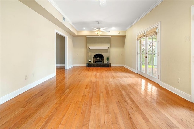 4516 Beau Lac Ln, Metairie, LA 70002 - unfurnished living room featuring crown molding, light wood-type flooring, a ceiling fan, a fireplace with raised hearth, and french doors