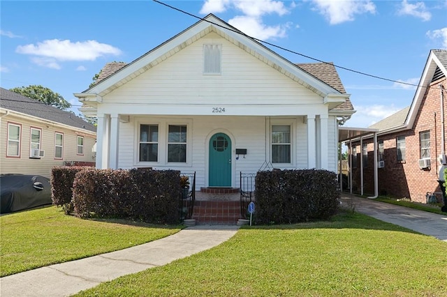 2524 Hamilton St, New Orleans, LA 70118 - view of front facade with a shingled roof, a porch, driveway, and a front lawn