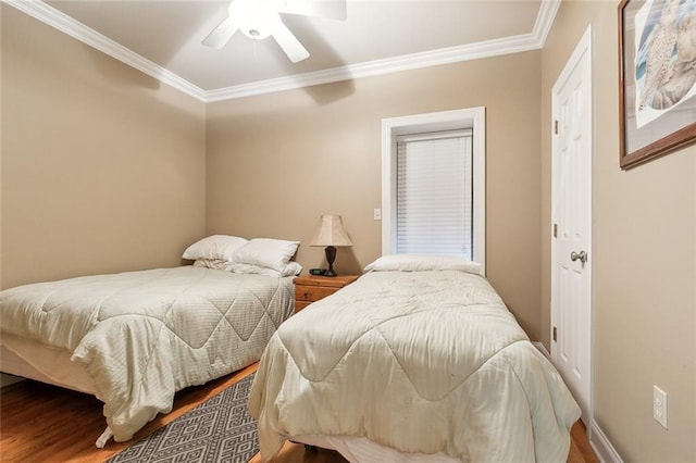 bedroom with crown molding, baseboards, a ceiling fan, and wood finished floors