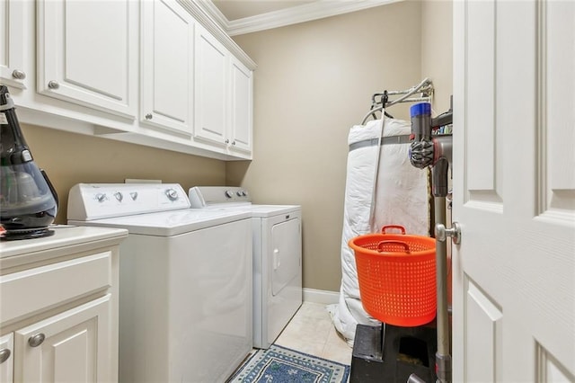 washroom with cabinet space, ornamental molding, washer and dryer, and light tile patterned floors