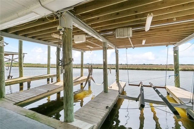 view of dock with boat lift and a water view
