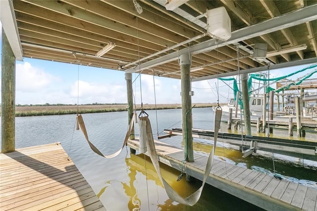 view of dock with boat lift and a water view