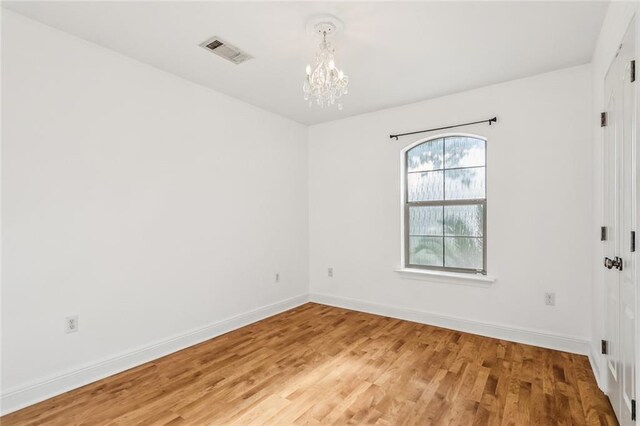 40339 Chandler Dr, Ponchatoula, LA 70454 - spare room with visible vents, baseboards, light wood-type flooring, and an inviting chandelier