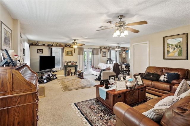 living area featuring a textured ceiling, carpet flooring, a ceiling fan, and visible vents