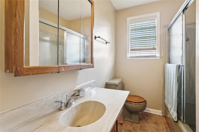 bathroom featuring a shower stall, vanity, baseboards, and toilet