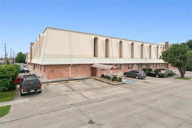 view of building exterior with uncovered parking