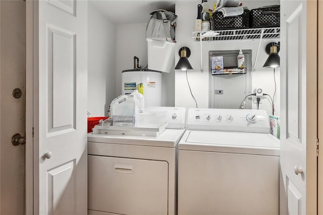 clothes washing area with independent washer and dryer, laundry area, and water heater