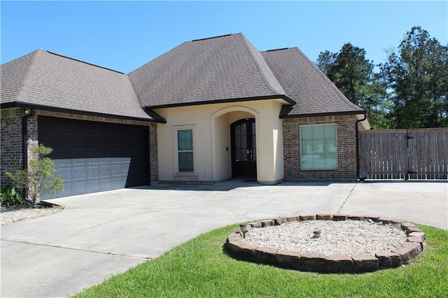 23620 Madisonville Ct, Ponchatoula, LA 70454 - french country home with a garage, brick siding, driveway, and roof with shingles