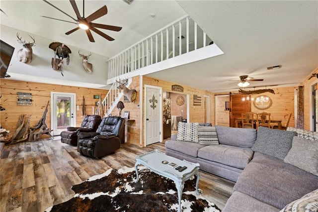 74307 Jack Lloyd Rd, Abita Springs, LA 70420 - living room with wooden walls, stairway, a ceiling fan, and wood finished floors