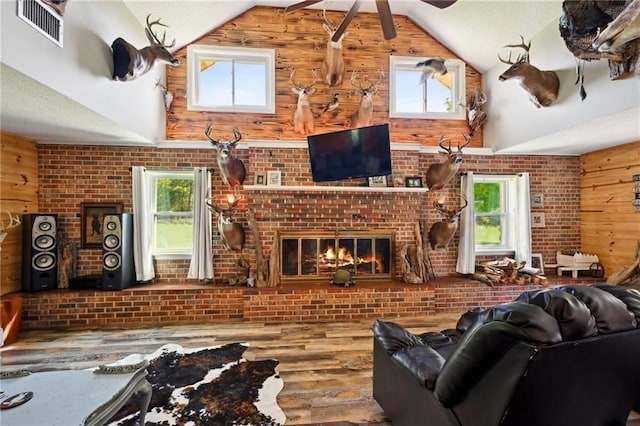 74307 Jack Lloyd Rd, Abita Springs, LA 70420 - living room featuring visible vents, a ceiling fan, wood finished floors, wood walls, and high vaulted ceiling
