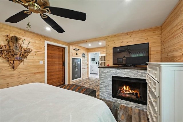 74307 Jack Lloyd Rd, Abita Springs, LA 70420 - bedroom with wood walls, a fireplace, a ceiling fan, and wood finished floors