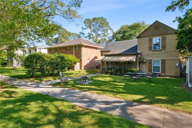 14 Wren St, New Orleans, LA 70124 - view of front of house with a front yard, a fire pit, and brick siding