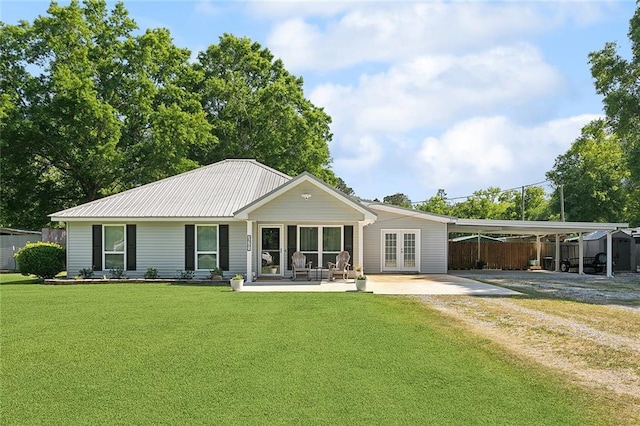 back of property with driveway, french doors, fence, an attached carport, and a yard