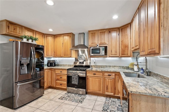 kitchen featuring wall chimney range hood, a sink, light tile patterned flooring, stainless steel appliances, and light stone countertops