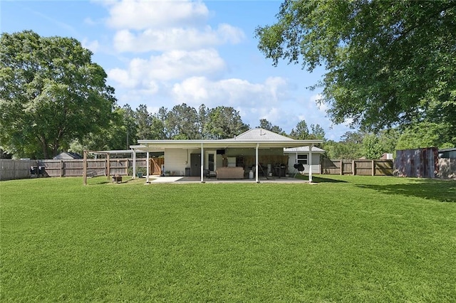 rear view of house with a lawn, a fenced backyard, and a patio