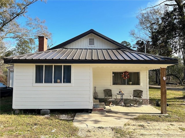 25821 Elsie Gill Rd, Holden, LA 70744 - back of house with a patio, metal roof, a yard, and a chimney