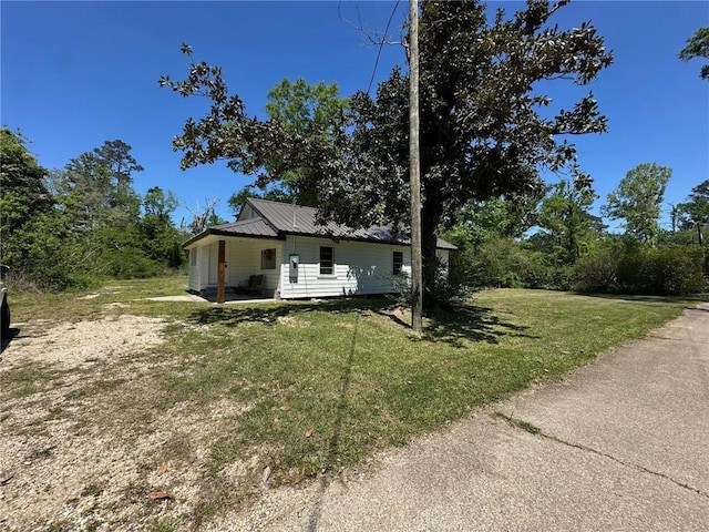 25821 Elsie Gill Rd, Holden, LA 70744 - view of property exterior with a yard and metal roof